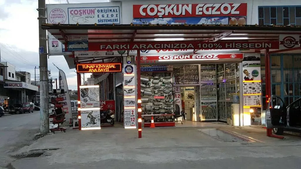Coşkun Egzoz işletmesinin ön cephesi ve egzoz parçalarının sergilendiği alan